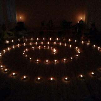 Erna Janisch, Lichtspirale, Brennende Teelichter in Form einer Spirale in einem dunklen Raum